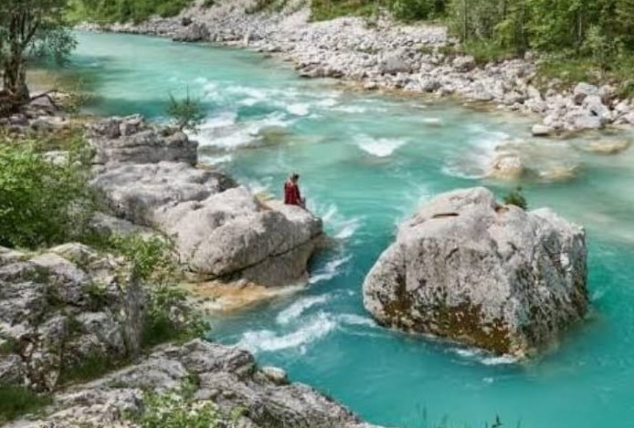 The emerald Soča river running between rocks in the Soča Valley