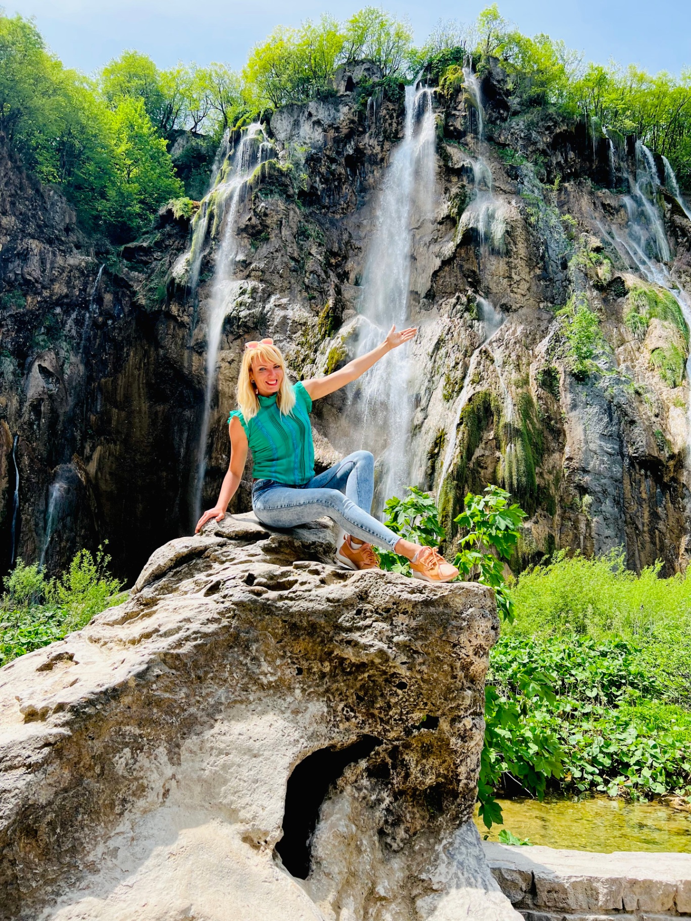 Your guide on a rock in front of the waterfalls of Plitvice Lakes National Park